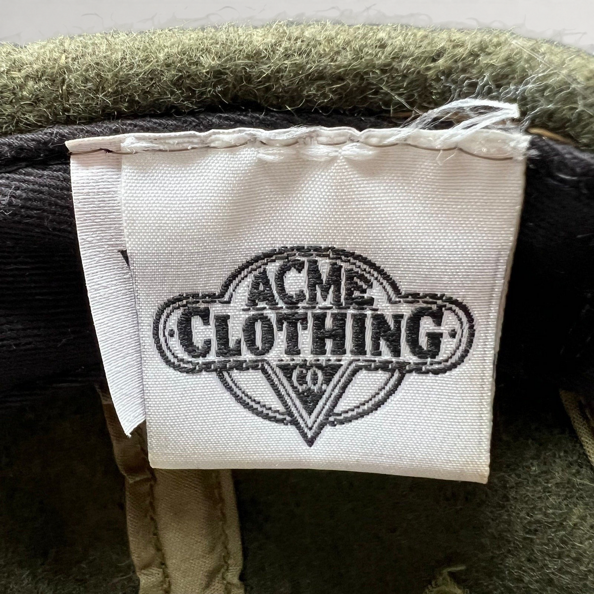 Raree Finds vintage 1991 Acme Clothing Co. interior brand tag inside an olive wool Harley-Davidson Taz hat