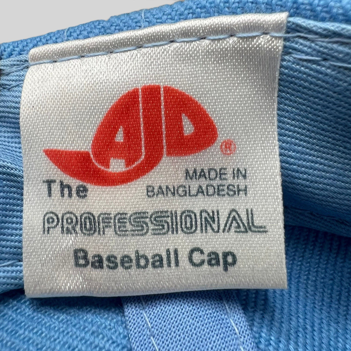 Raree Finds vintage AJD baseball cap interior fabric tag with red logo and Made in Bangladesh text