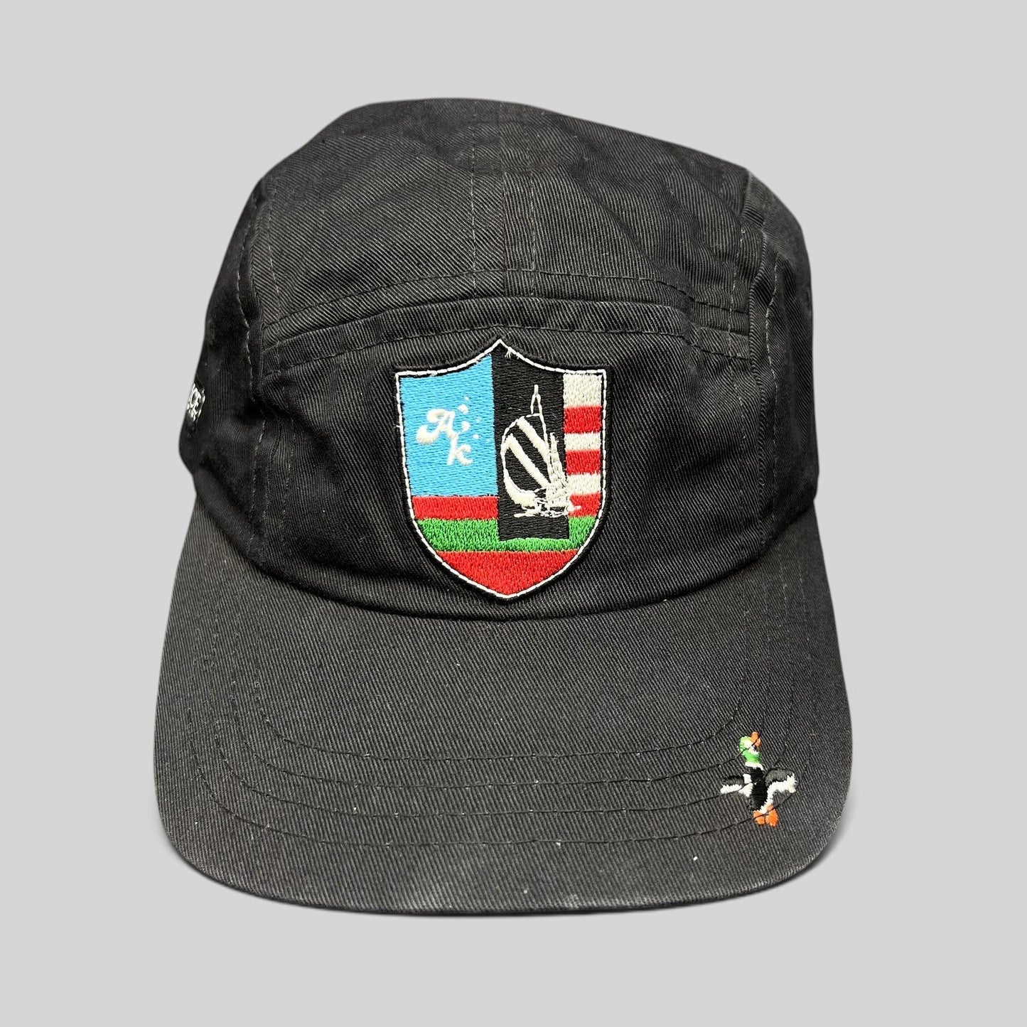 Raree Finds Akomplice Clothing black cotton strapback cap with a colorful embroidered crest patch and duck brim detail