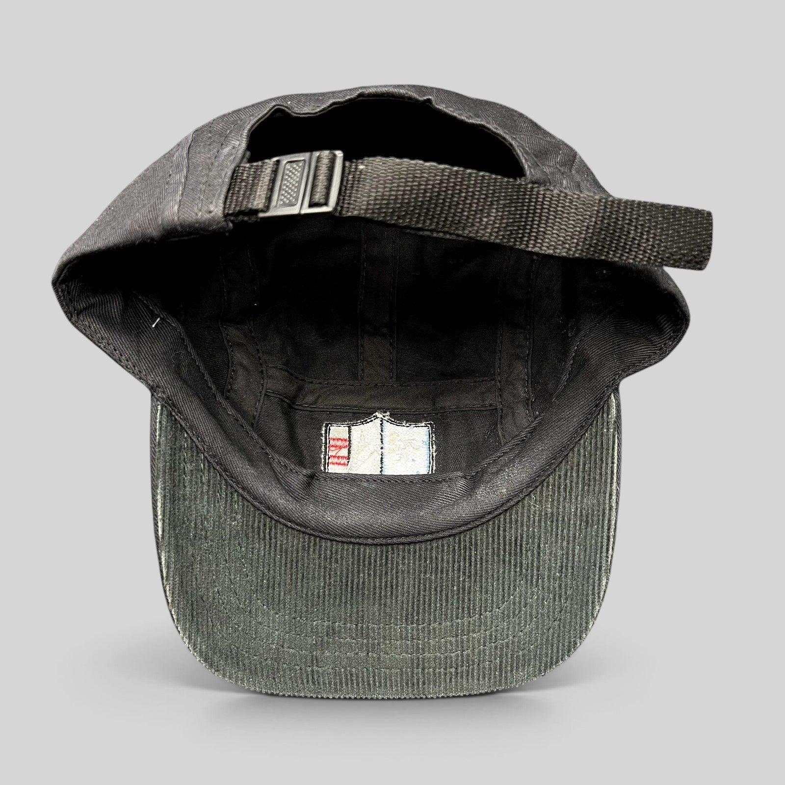 Raree Finds Akomplice Clothing black cotton strapback hat showing the interior lining and adjustable nylon strap