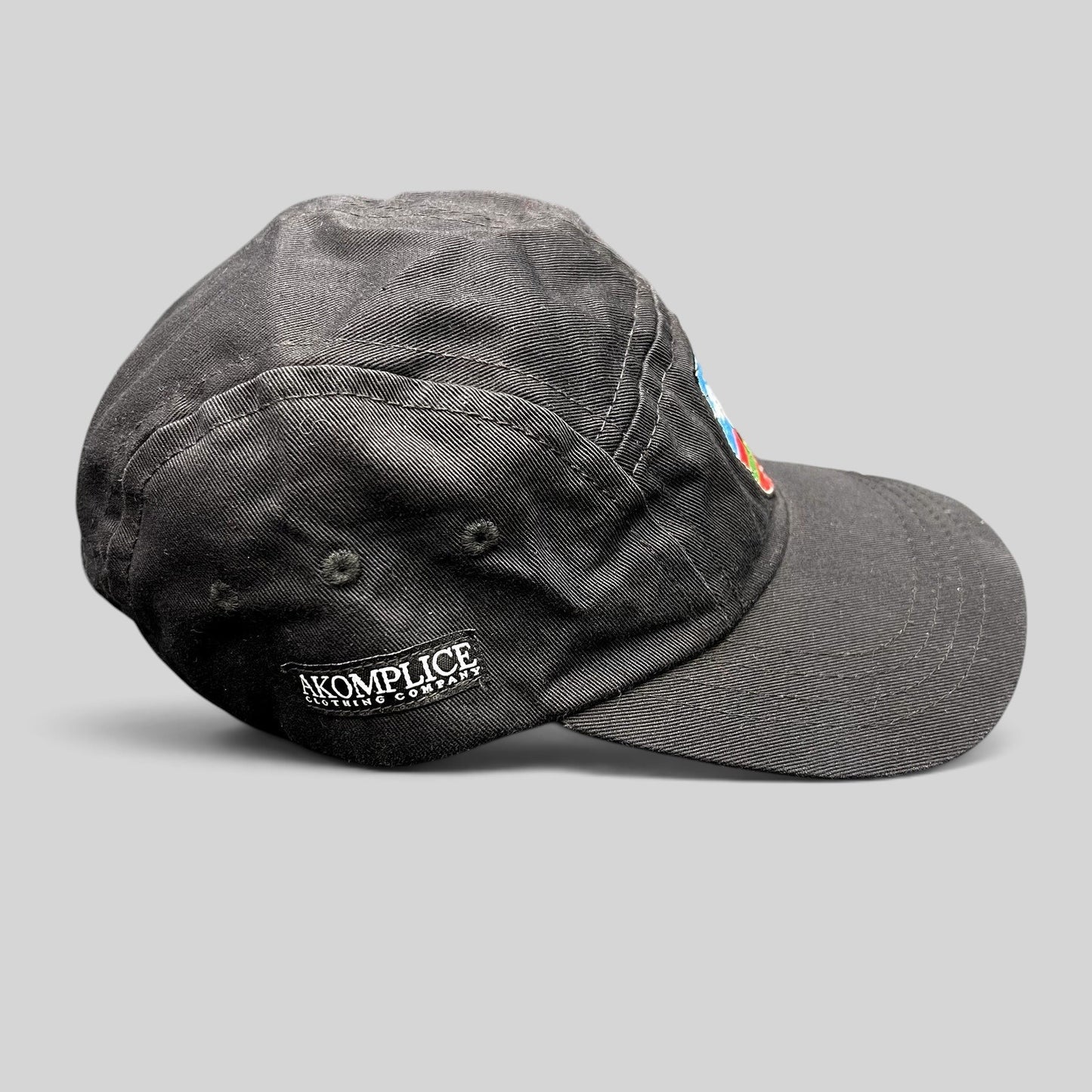 Raree Finds black Akomplice Clothing strapback hat with side logo embroidery and a front multicolor crest patch
