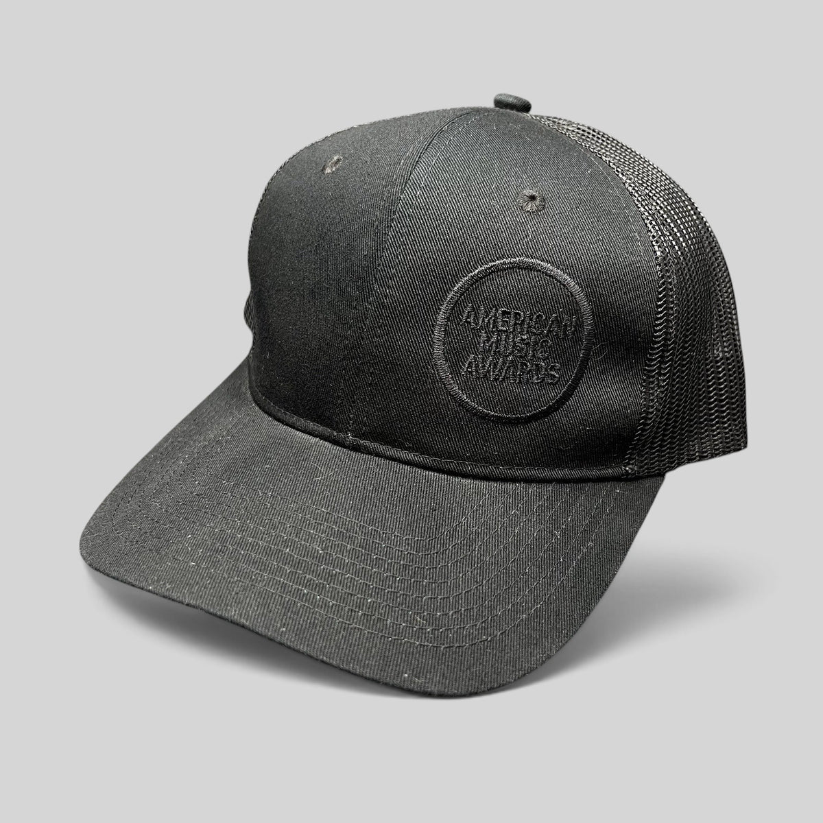 Raree Finds American Music Awards black trucker hat with tonal embroidered logo and mesh back panels.