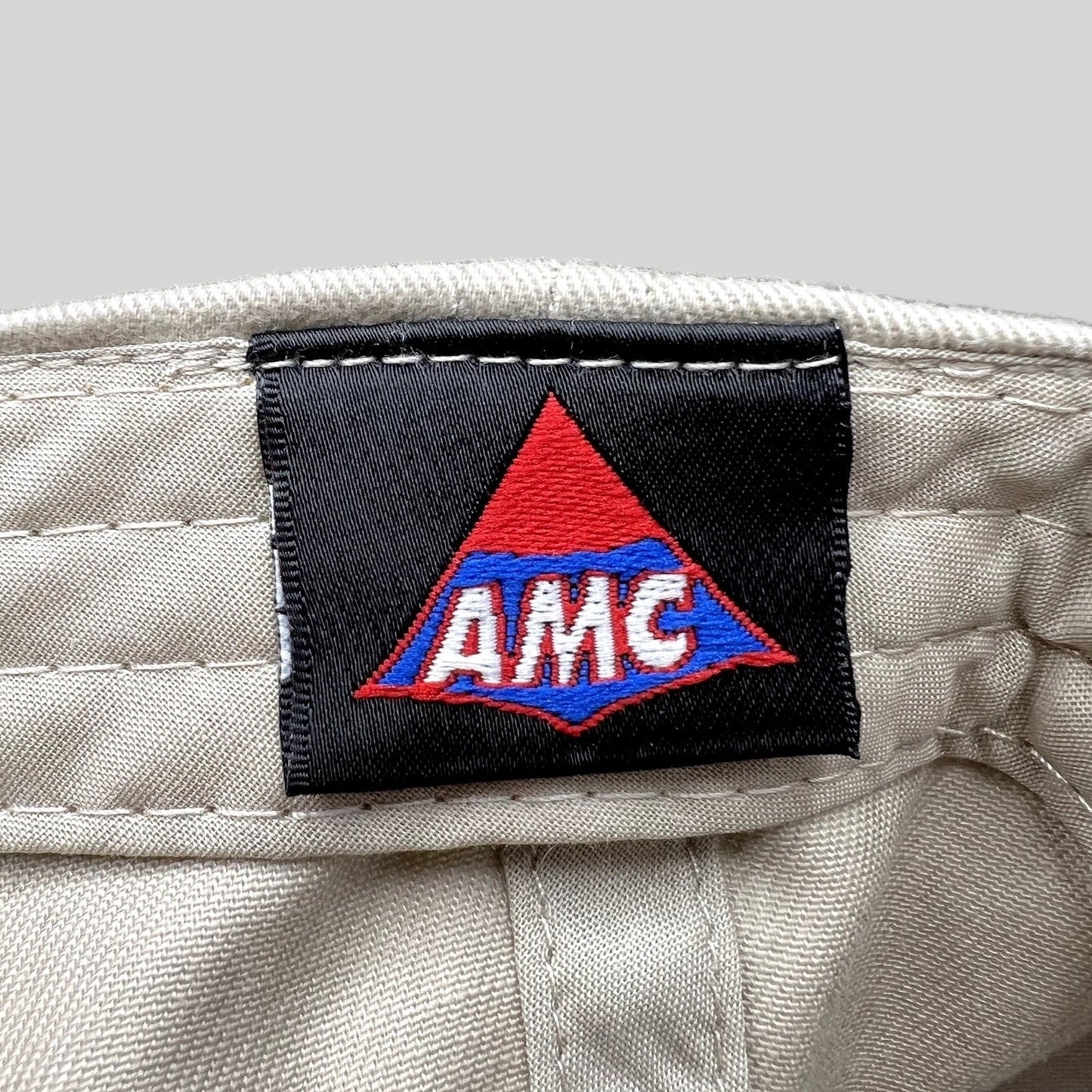 Raree Finds Land of the Lost movie promo hat interior tag featuring the AMC logo on a black woven label