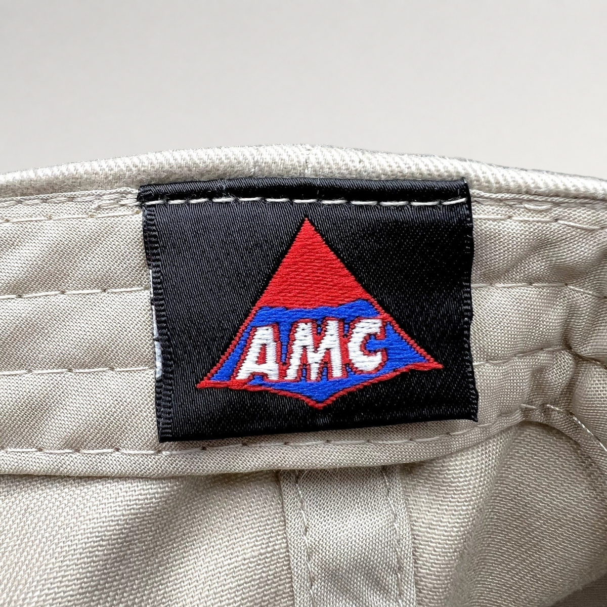 Raree Finds Land of the Lost movie promo hat interior tag featuring the AMC logo on a black woven label