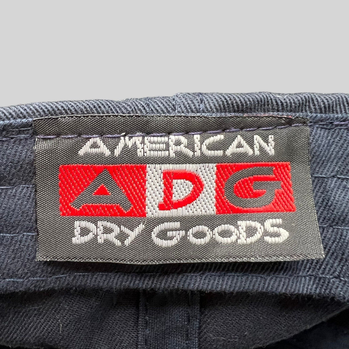 Raree Finds American Needle ADG clothing label stitched on a black cotton hat interior