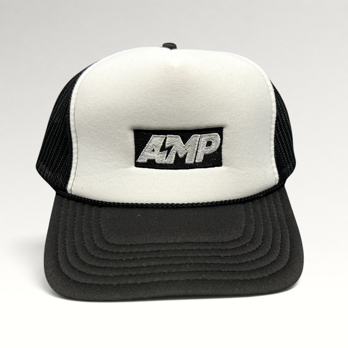Raree Finds vintage AMP trucker hat with white foam front, black mesh back, and embroidered logo on a curved brim.