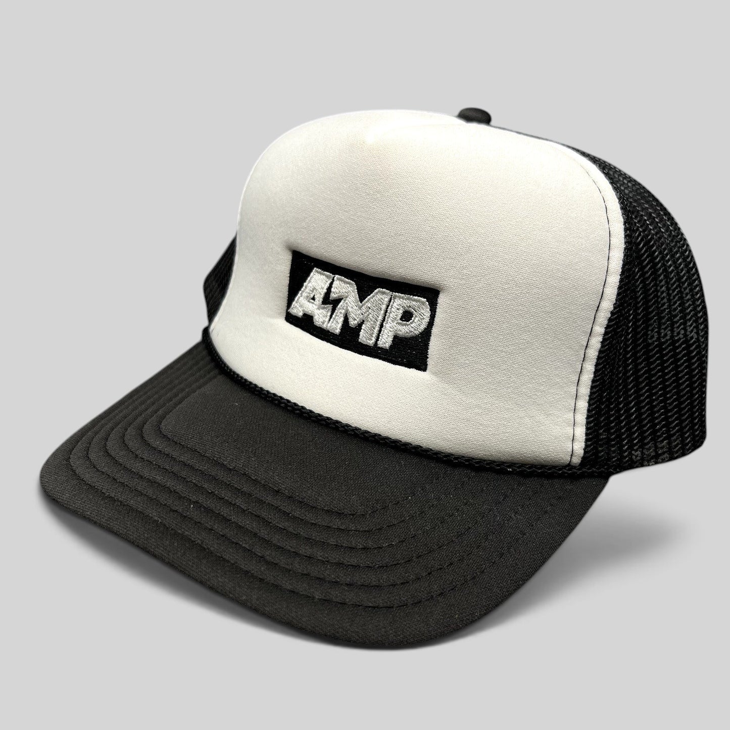 Raree Finds vintage AMP Any Means Possible trucker hat with white foam front, black mesh back, and embroidered logo.