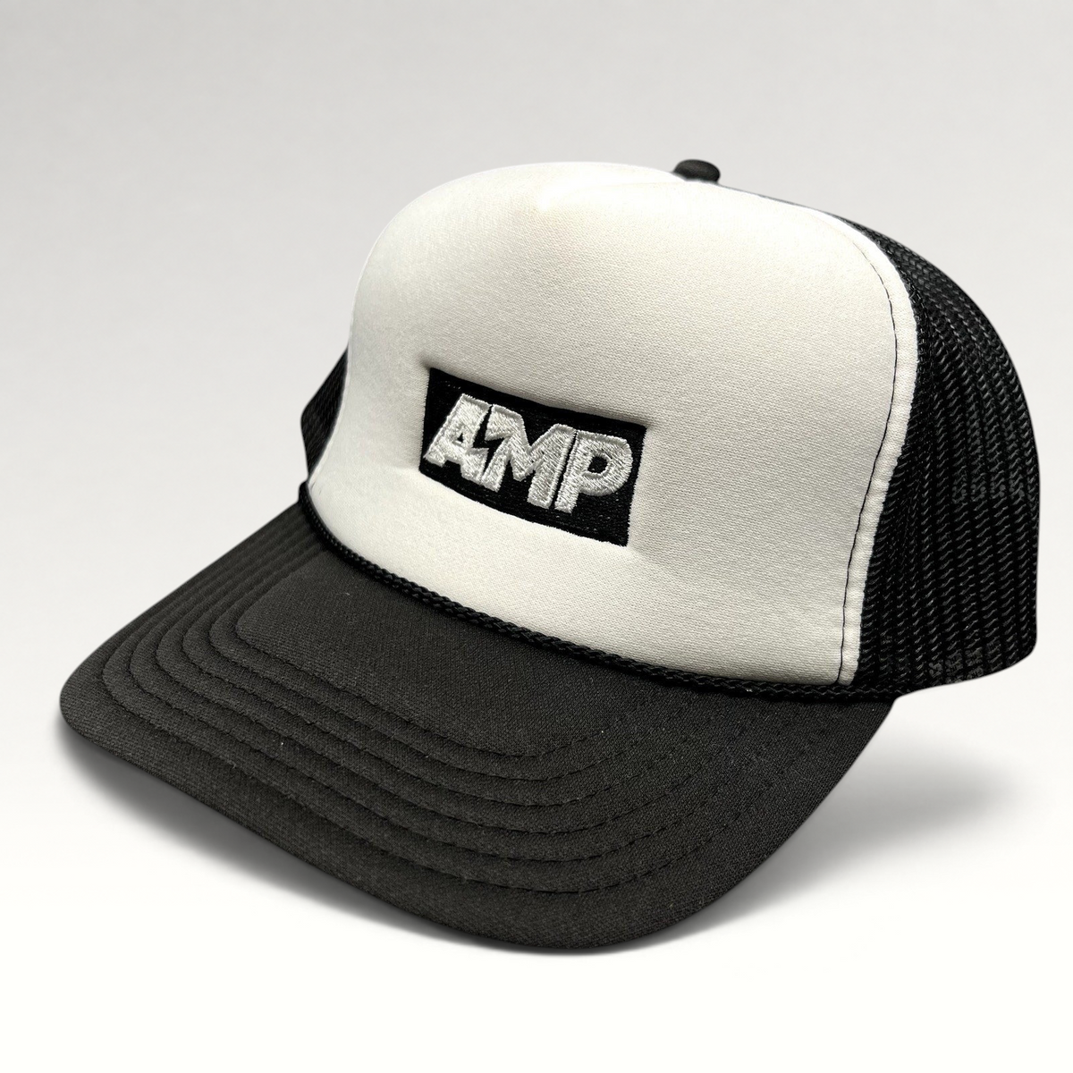 Raree Finds vintage AMP Any Means Possible trucker hat with white foam front, black mesh back, and embroidered logo.