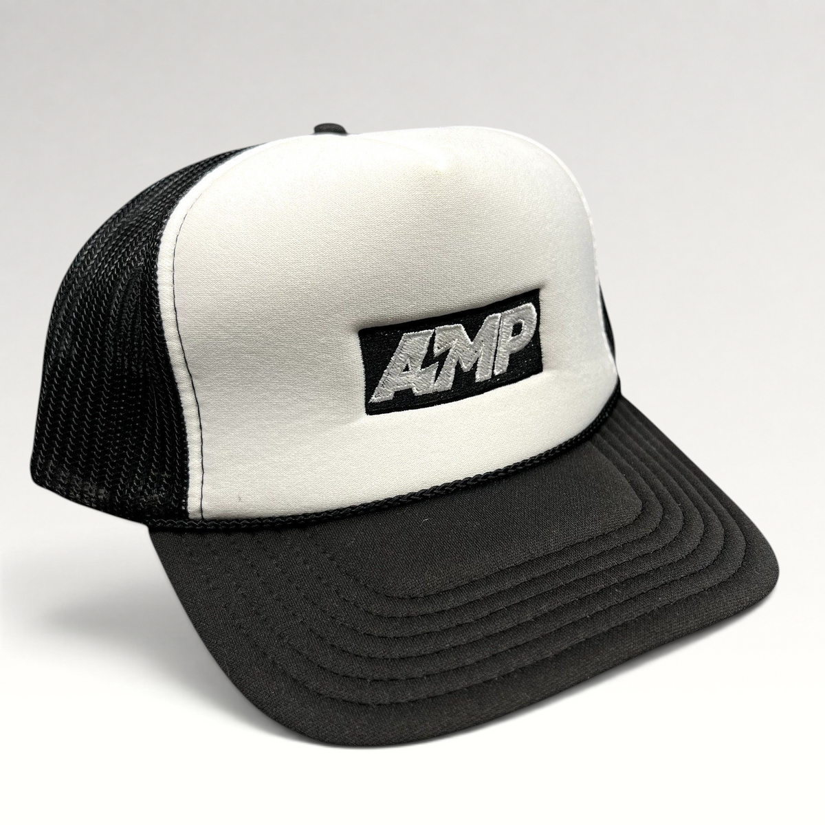Raree Finds vintage AMP Any Means Possible trucker hat with a white foam front, black mesh back, and snapback closure.