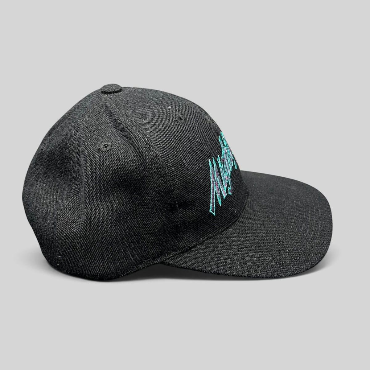 Raree Finds vintage Anaheim Mighty Ducks snapback hat in black with teal and purple script embroidery on a flat bill.