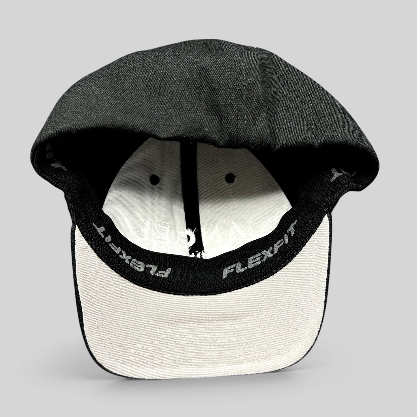 Raree Finds black Angel Studios Flexfit cap with white interior lining and branded sweatband, viewed from underneath.