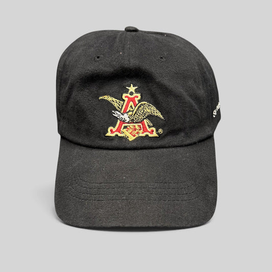 Raree Finds black cotton strapback hat featuring an embroidered Anheuser-Busch A and Eagle logo on the front.