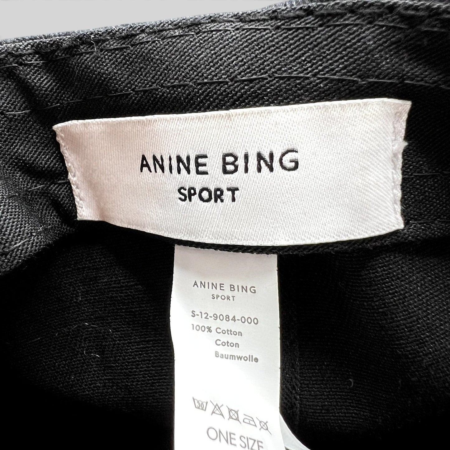 Raree Finds Anine Bing Sport black cotton cap interior label showing brand logo and fabric composition details