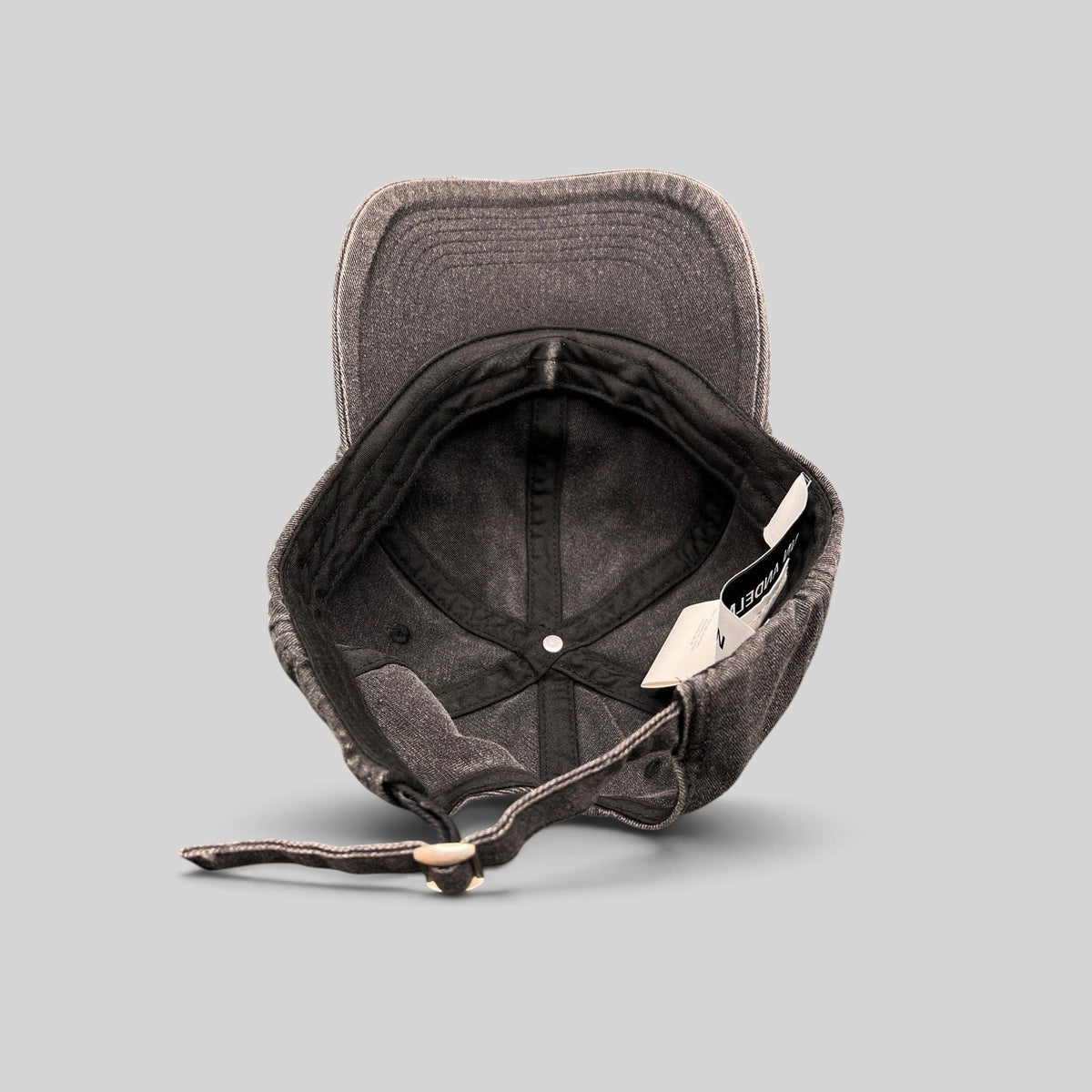 Raree Finds Ann Andelman black denim baseball cap, showing the interior, adjustable strap, and distressed brim.