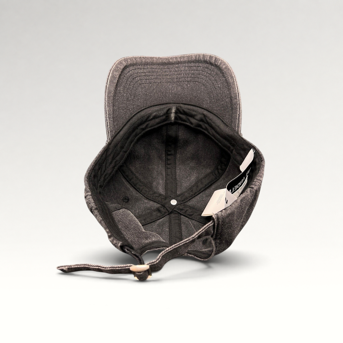 Raree Finds Ann Andelman black denim baseball cap, showing the interior, adjustable strap, and distressed brim.