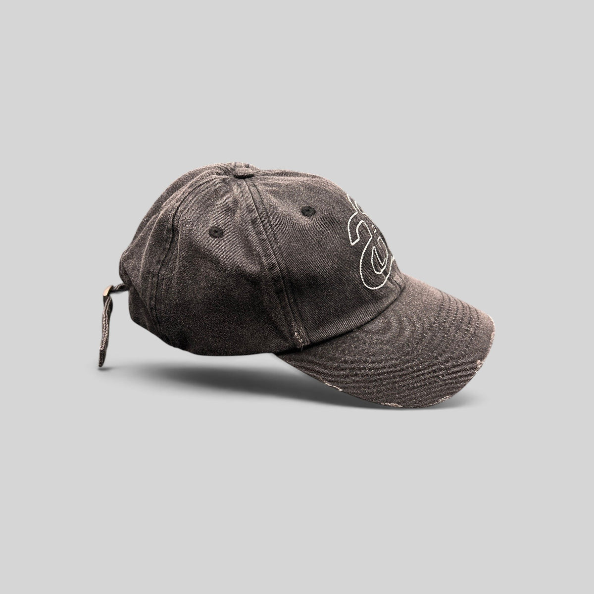 Raree Finds Ann Andelman black denim baseball cap with white monogram logo and distressed brim detail.