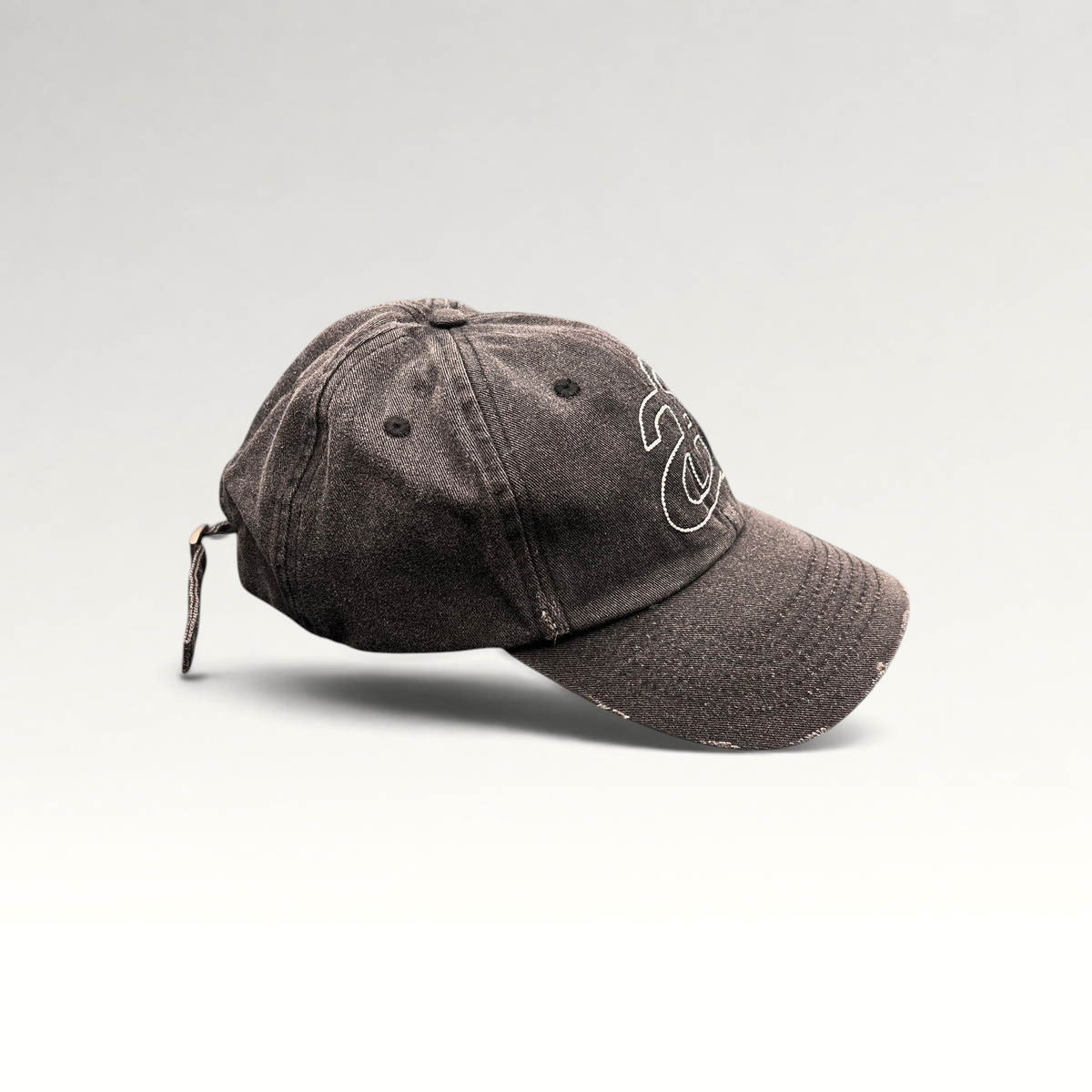 Raree Finds Ann Andelman black denim baseball cap with white monogram logo and distressed brim detail.