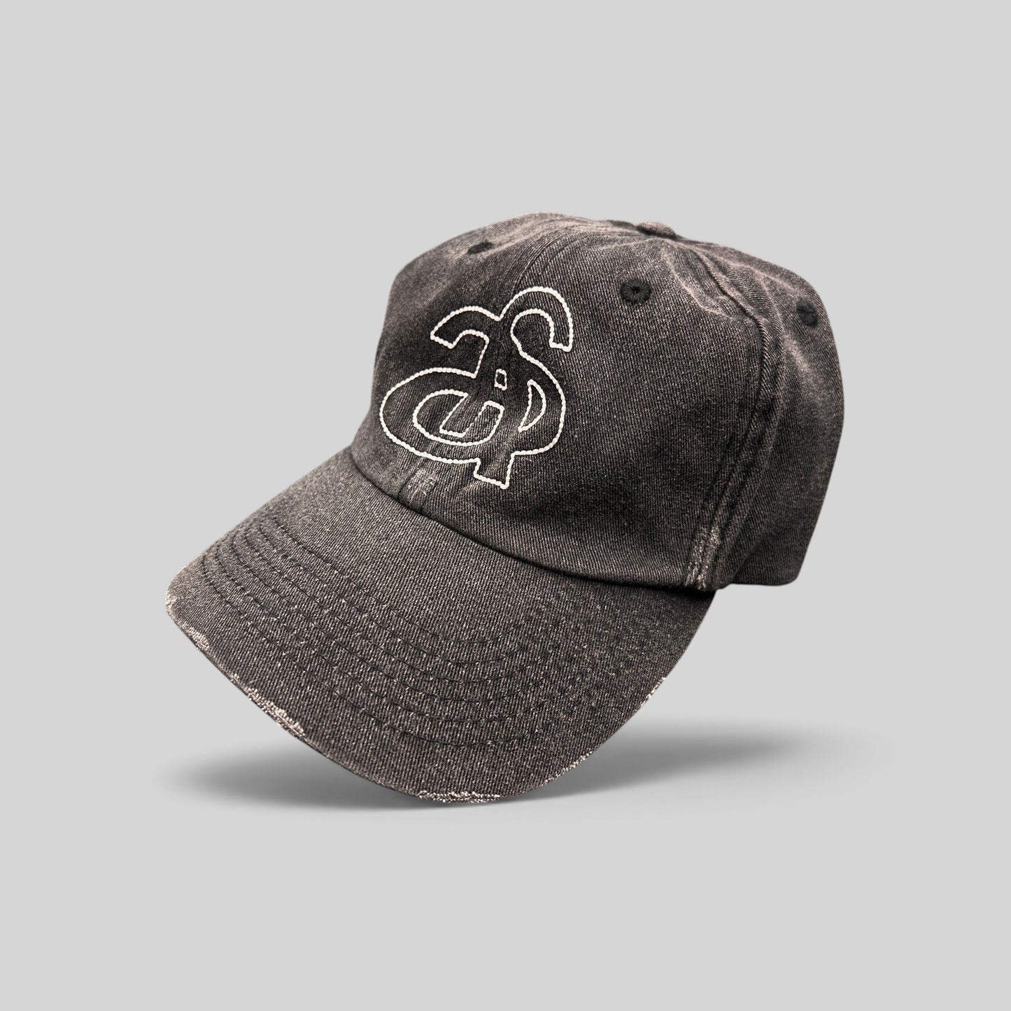 Raree Finds Ann Andelman black denim baseball cap with white embroidered monogram logo and distressed brim detail.