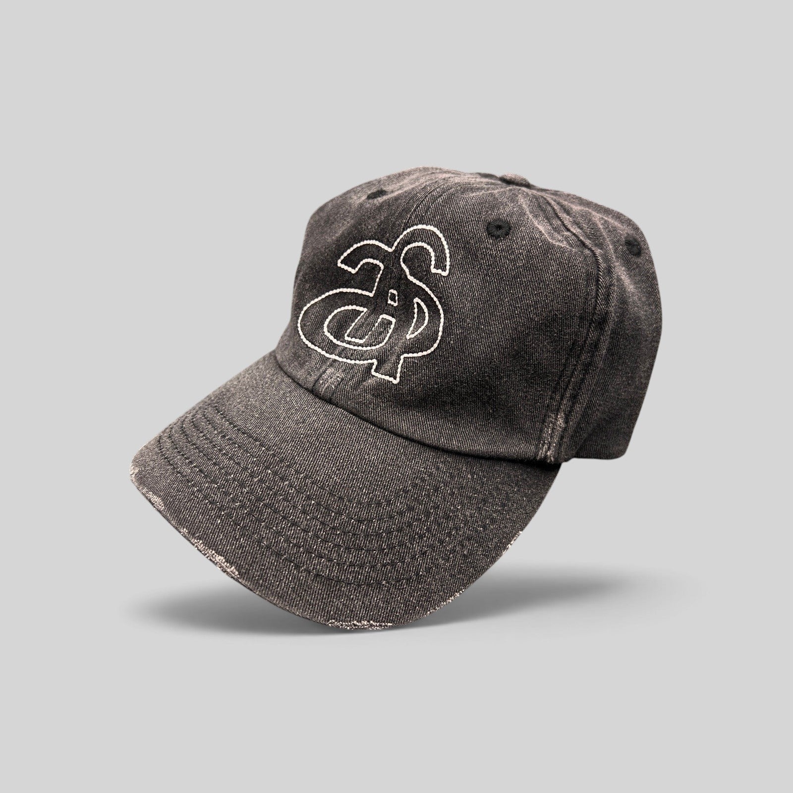 Raree Finds Ann Andelman black denim baseball cap with white embroidered monogram logo and distressed brim detail.