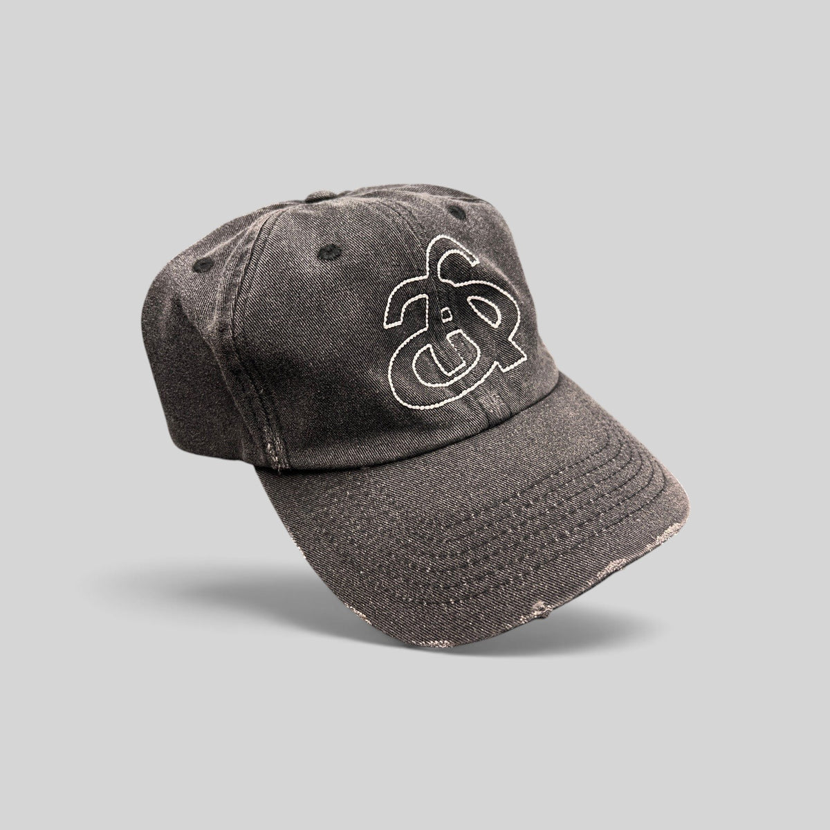 Raree Finds Ann Andelman black denim baseball cap with white embroidered monogram logo and distressed brim detail.