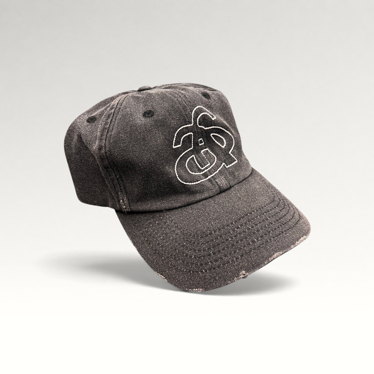 Raree Finds Ann Andelman black denim baseball cap with white embroidered monogram logo and distressed brim detail.