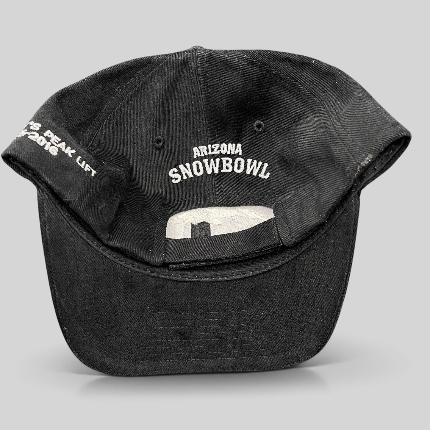 Raree Finds black Yupoong strapback hat featuring Arizona Snowbowl embroidery on the back and Humphreys Peak text.