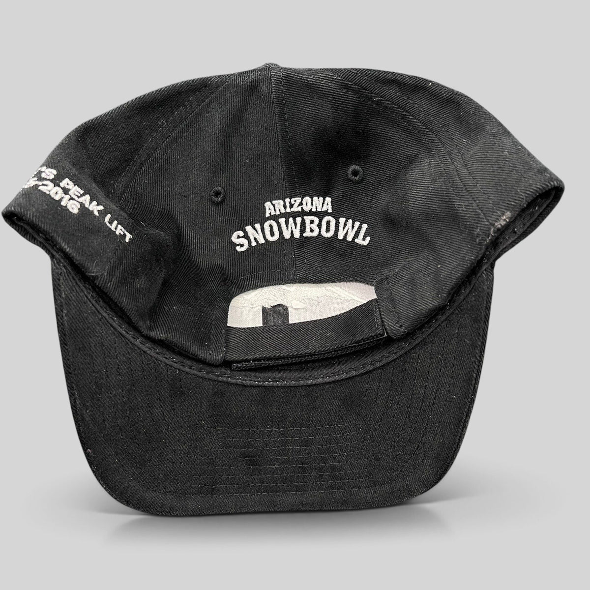 Raree Finds black Yupoong strapback hat featuring Arizona Snowbowl embroidery on the back and Humphreys Peak text.