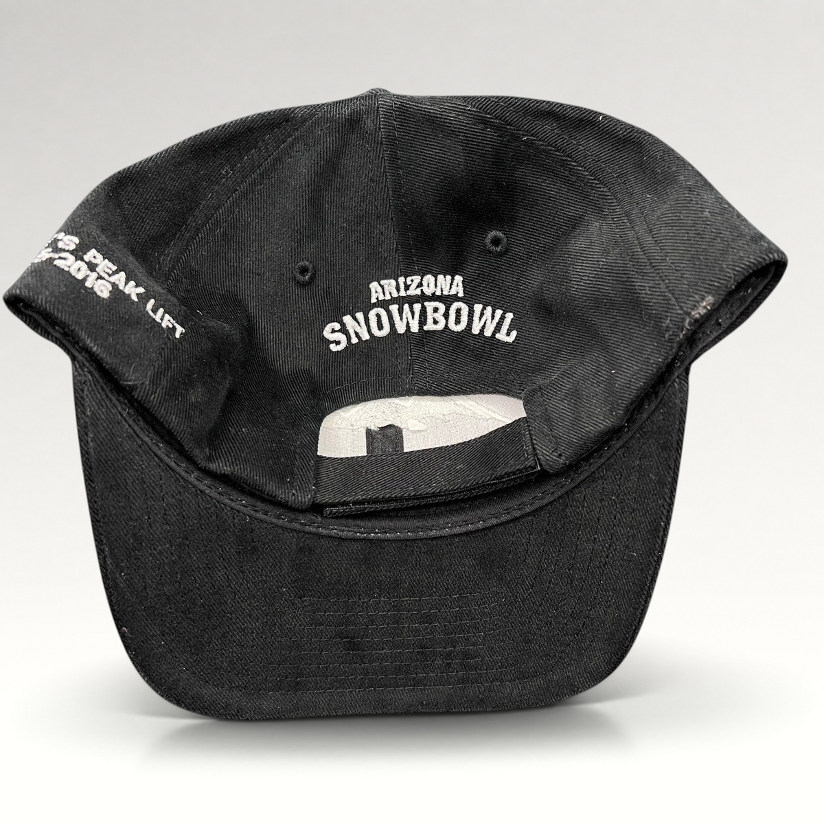 Raree Finds black Yupoong strapback hat featuring Arizona Snowbowl embroidery on the back and Humphreys Peak text.