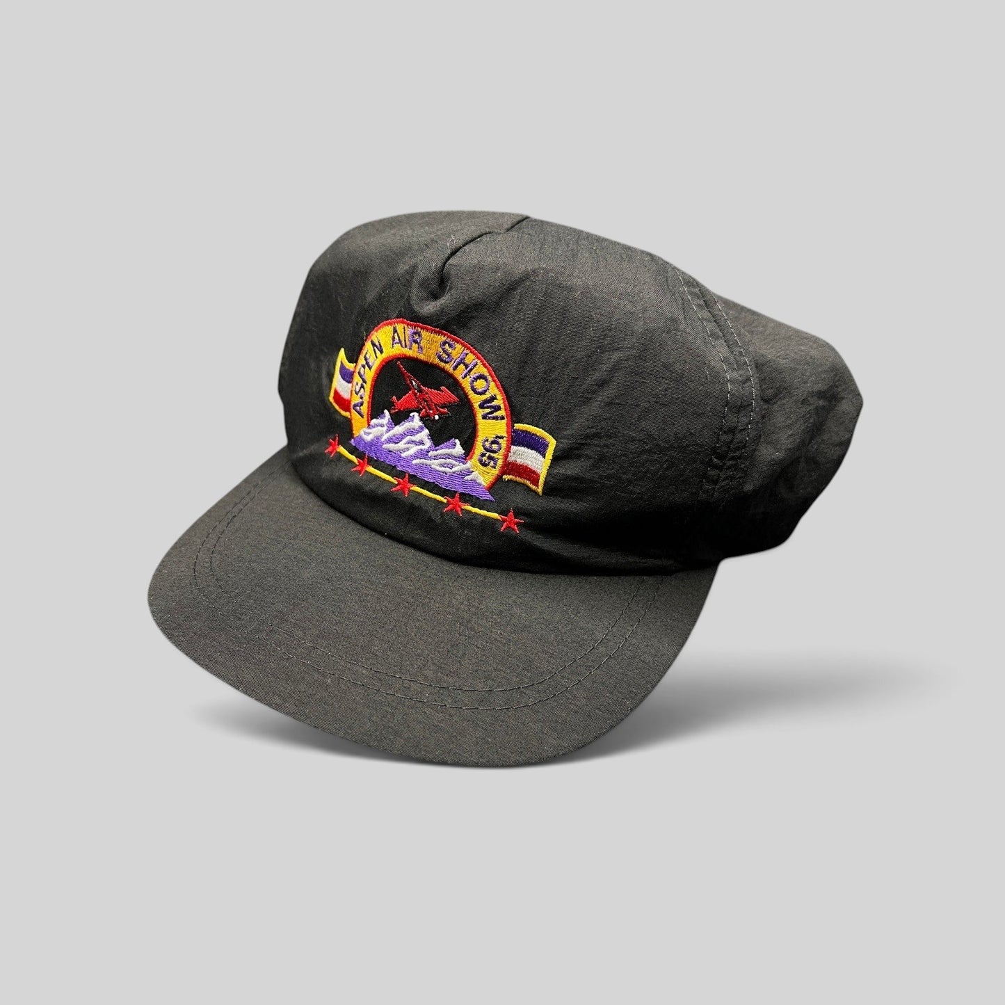 Raree Finds vintage 1995 Aspen Air Show black nylon snapback hat with multicolor jet and mountain embroidery