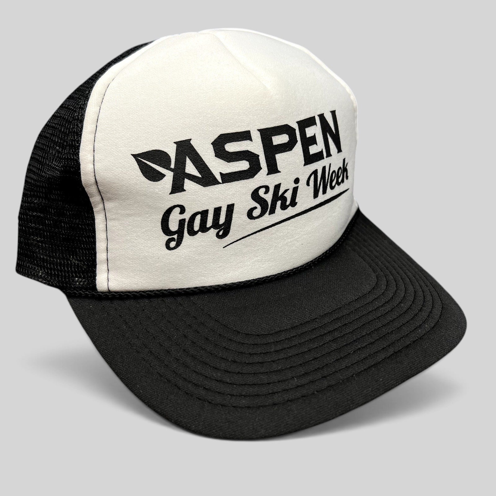 Raree Finds vintage Aspen Gay Ski Week Otto trucker hat with black script on white foam front and black mesh back.