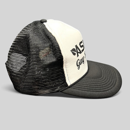 Raree Finds vintage Aspen Gay Ski Week trucker hat with white foam front, black mesh back, and black brim.