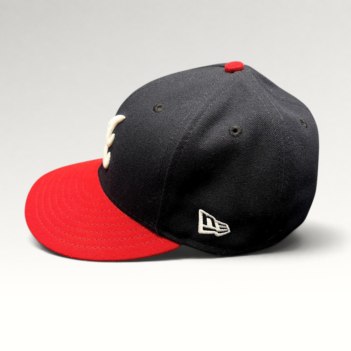 Raree Finds Atlanta Braves 59FIFTY fitted hat with navy crown, red visor, and white embroidered logo on side profile.