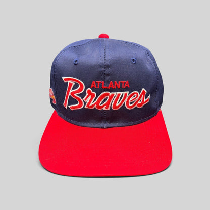 Raree Finds vintage 90s Atlanta Braves Sports Specialties snapback hat with navy crown, red brim, and script logo.