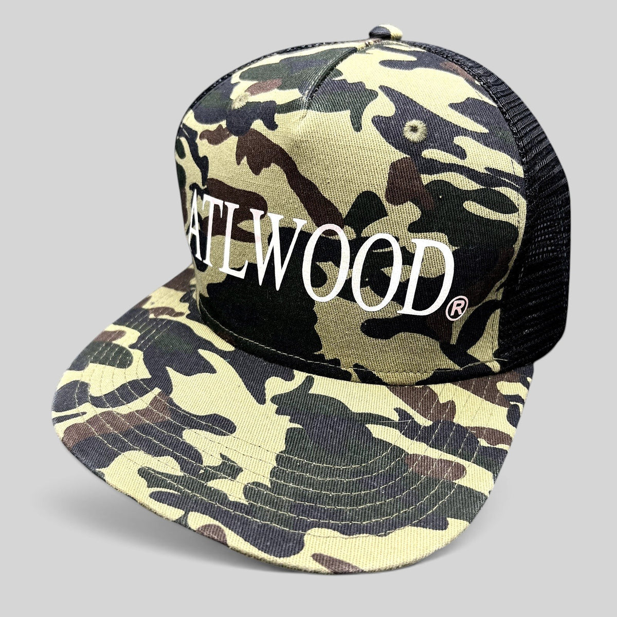 Raree Finds ATLWOOD woodland camo trucker hat with black mesh back and white embroidered logo on a flat brim