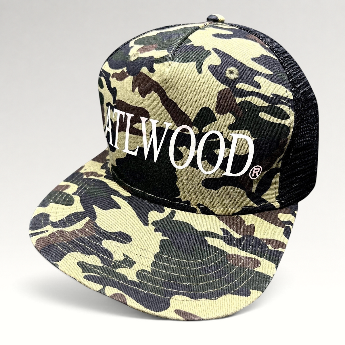 Raree Finds ATLWOOD woodland camo trucker hat with black mesh back and white embroidered logo on a flat brim