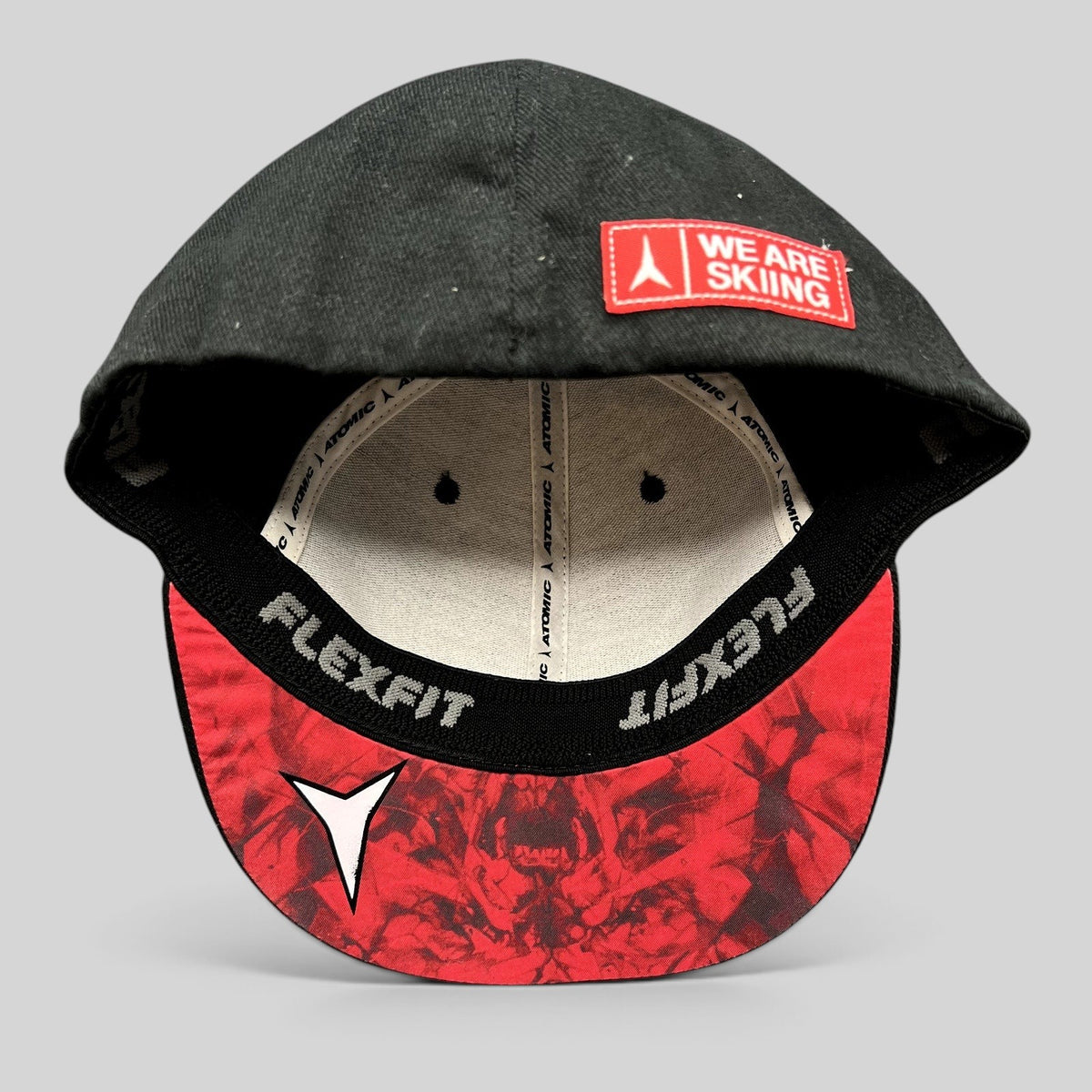 Raree Finds black Atomic Skis FlexFit cap with red graphic undervisor and We Are Skiing embroidery on the brim
