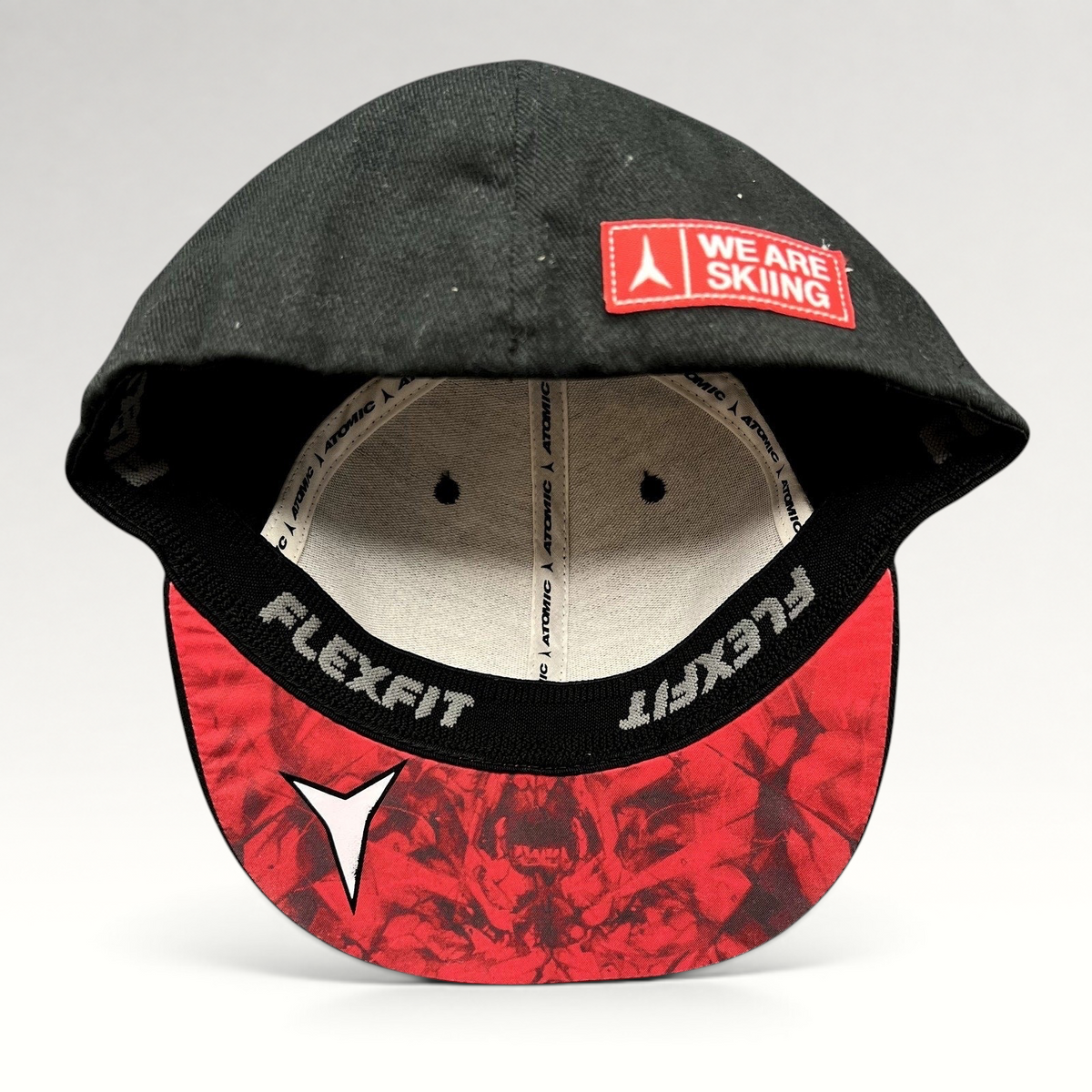 Raree Finds black Atomic Skis FlexFit cap with red graphic undervisor and We Are Skiing embroidery on the brim