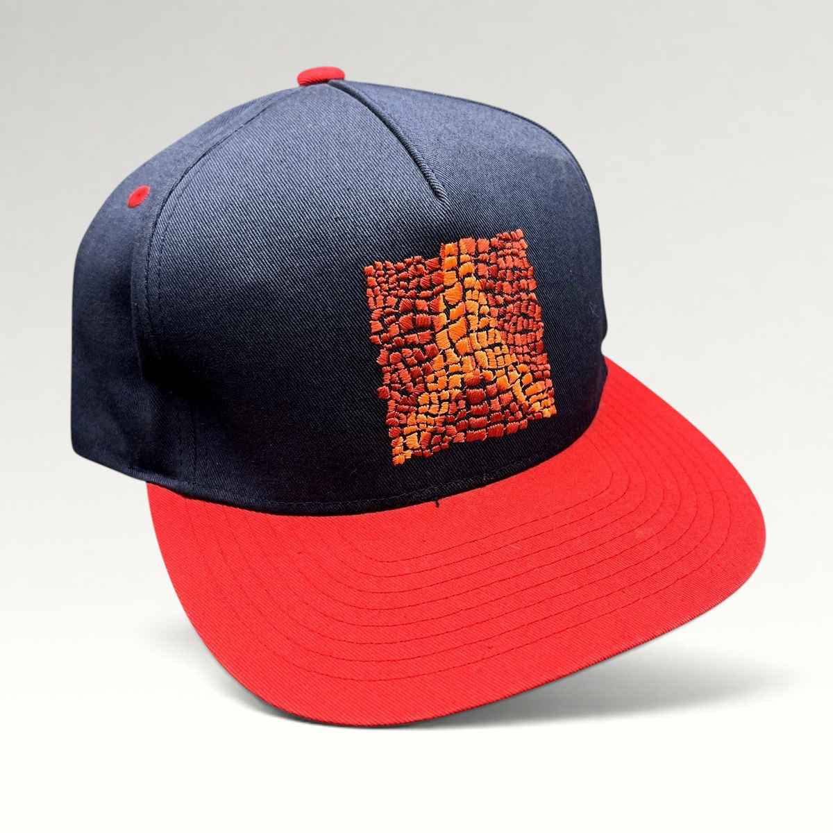 Raree Finds Atomic Skis navy snapback hat with red flat brim and embroidered Eiffel Tower mosaic graphic
