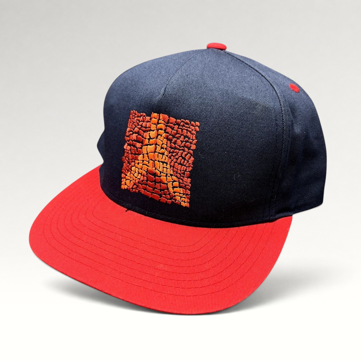 Raree Finds Atomic Skis snapback hat with navy crown, red flat brim, and embroidered Eiffel Tower mosaic graphic.