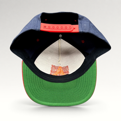 Raree Finds Atomic Skis snapback hat showing the green undervisor, red snap closure, and interior embroidery detail.
