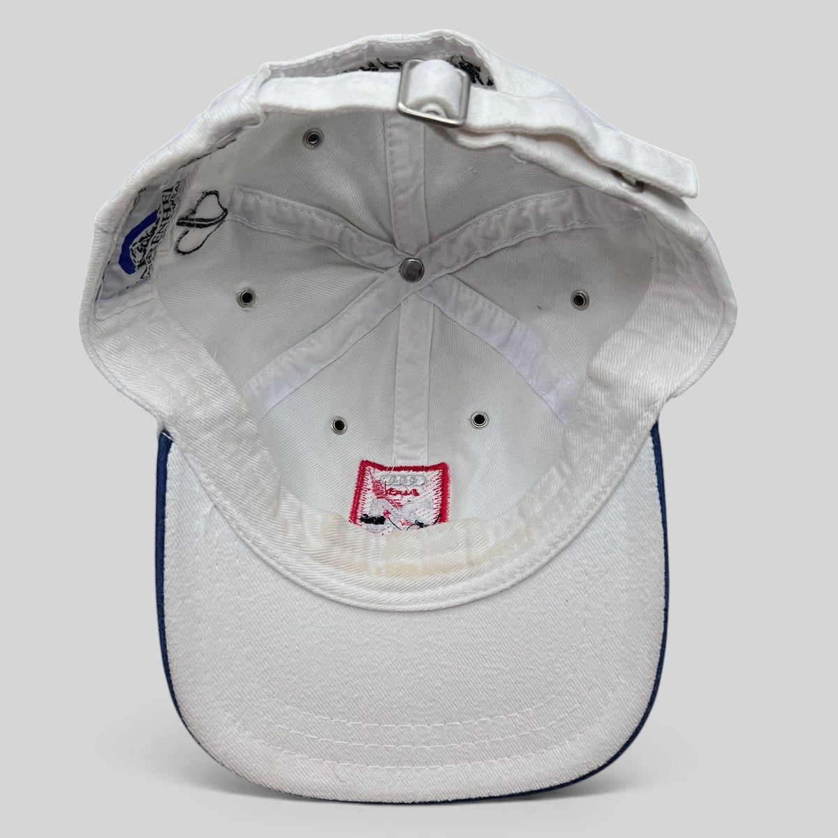 Raree Finds vintage white Audi 24 HRS of Aspen cotton strapback hat, interior view showing metal eyelets and branding.
