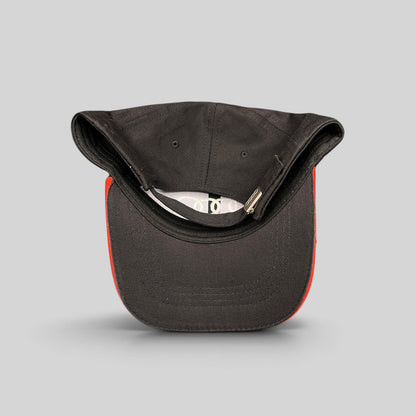 Raree Finds Audi black cotton twill strapback hat with red underbrim accent and metal clasp, top-down view.