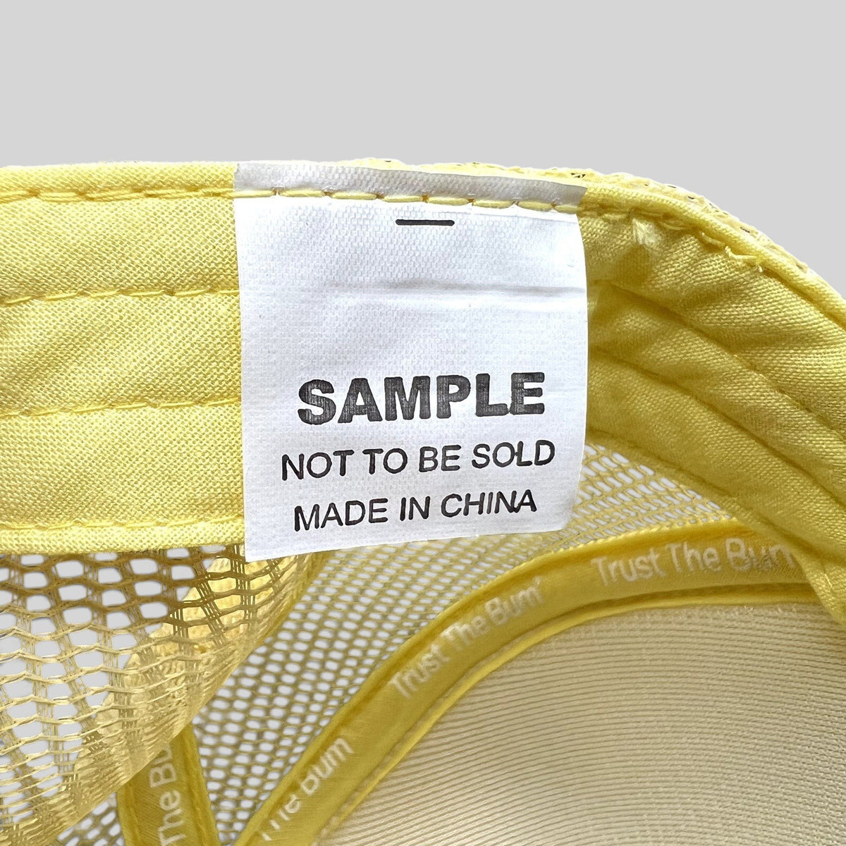 Raree Finds Baby Bum trucker hat interior tag reading SAMPLE NOT TO BE SOLD in yellow mesh and foam construction