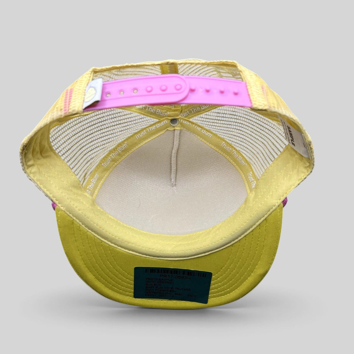Raree Finds Baby Bum prototype trucker hat interior view showing yellow foam, pink snapback, and branded tape.