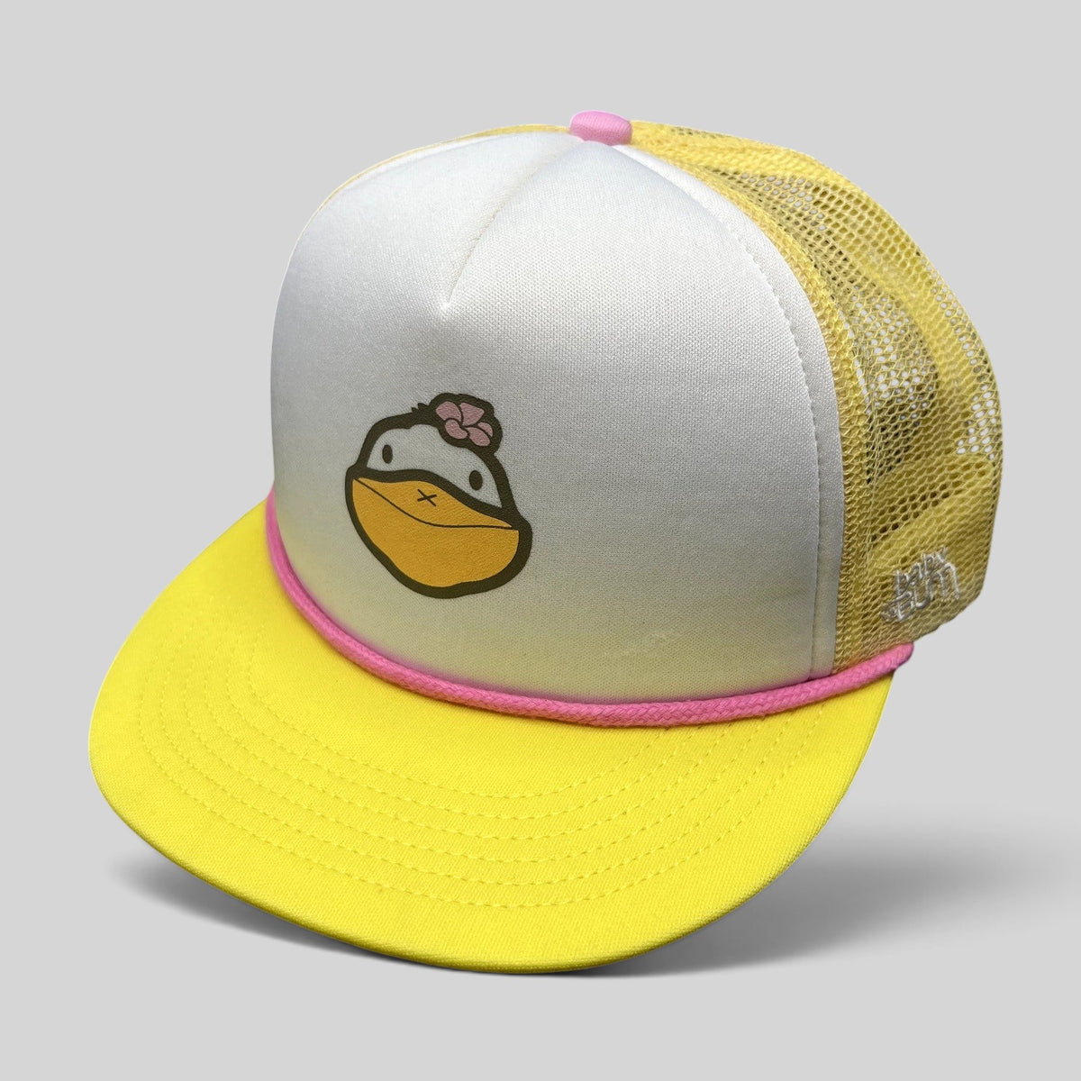 Raree Finds Baby Bum prototype trucker hat with white foam front, yellow mesh back, pink rope trim, and duck graphic.