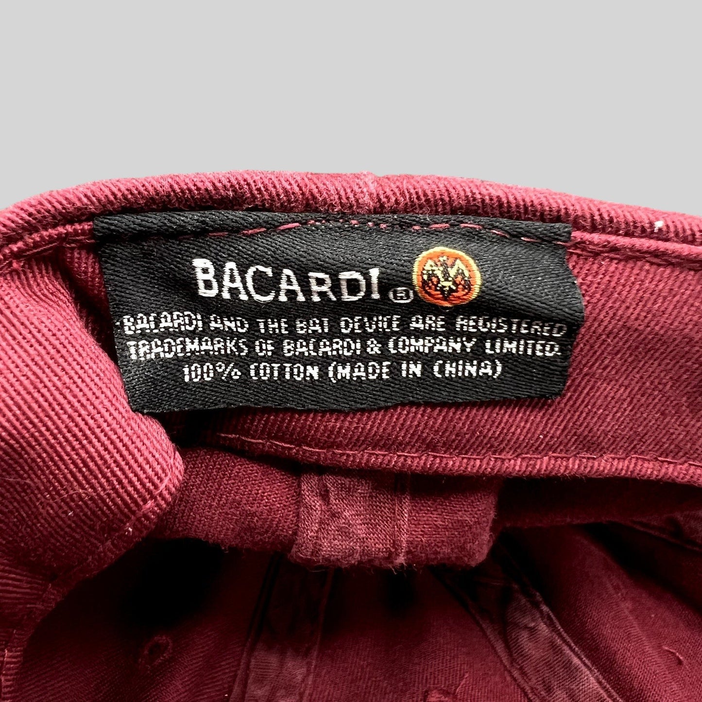 Raree Finds vintage Bacardi hat interior label showing 100% cotton material and brand logo on burgundy fabric