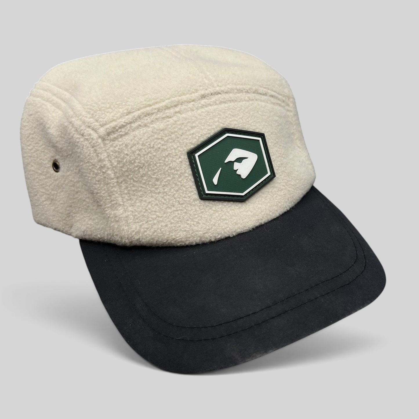 Raree Finds Baldface strapback hat with a cream fleece crown, black bill, and a green rubber logo patch.