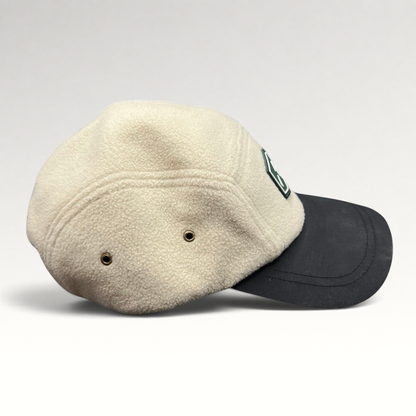 Raree Finds Baldface strapback hat with a cream fleece crown, black bill, and rubber logo patch, side profile view.