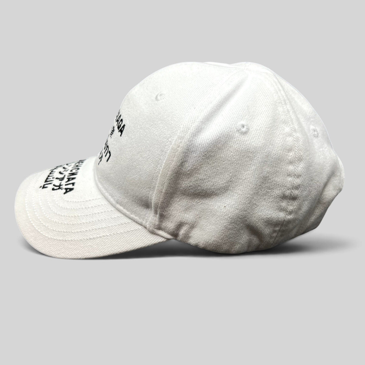 Raree Finds white Balenciaga strapback hat with black multilingual logo embroidery on the front and brim