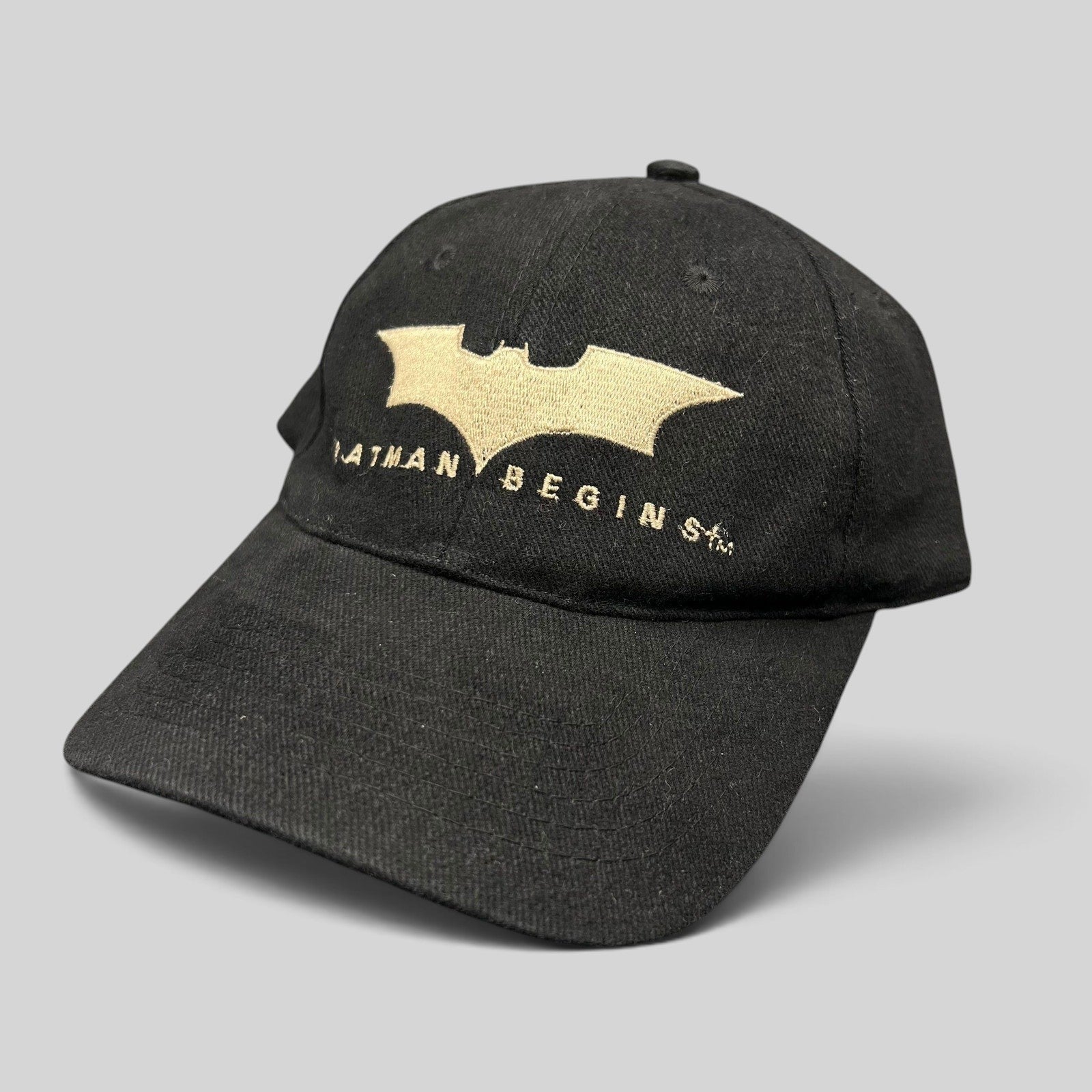 Raree Finds vintage 2005 Batman Begins black cotton strapback hat with tan embroidered bat symbol and movie logo